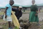 Malaki unser Ecolehrer hilft den Kindern beim einpflanzen